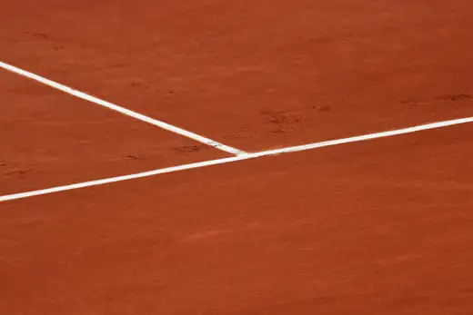 Weiße Linien auf dem roten Sand einer Tennisanlage